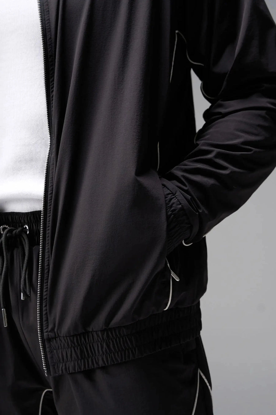 Detail  View of Black TLF Track Jacket (Men’s GTS Gym-To-Street Edition) with mesh lining, reflective piping, and premium trims for all-day Gym-To-Street wear. 