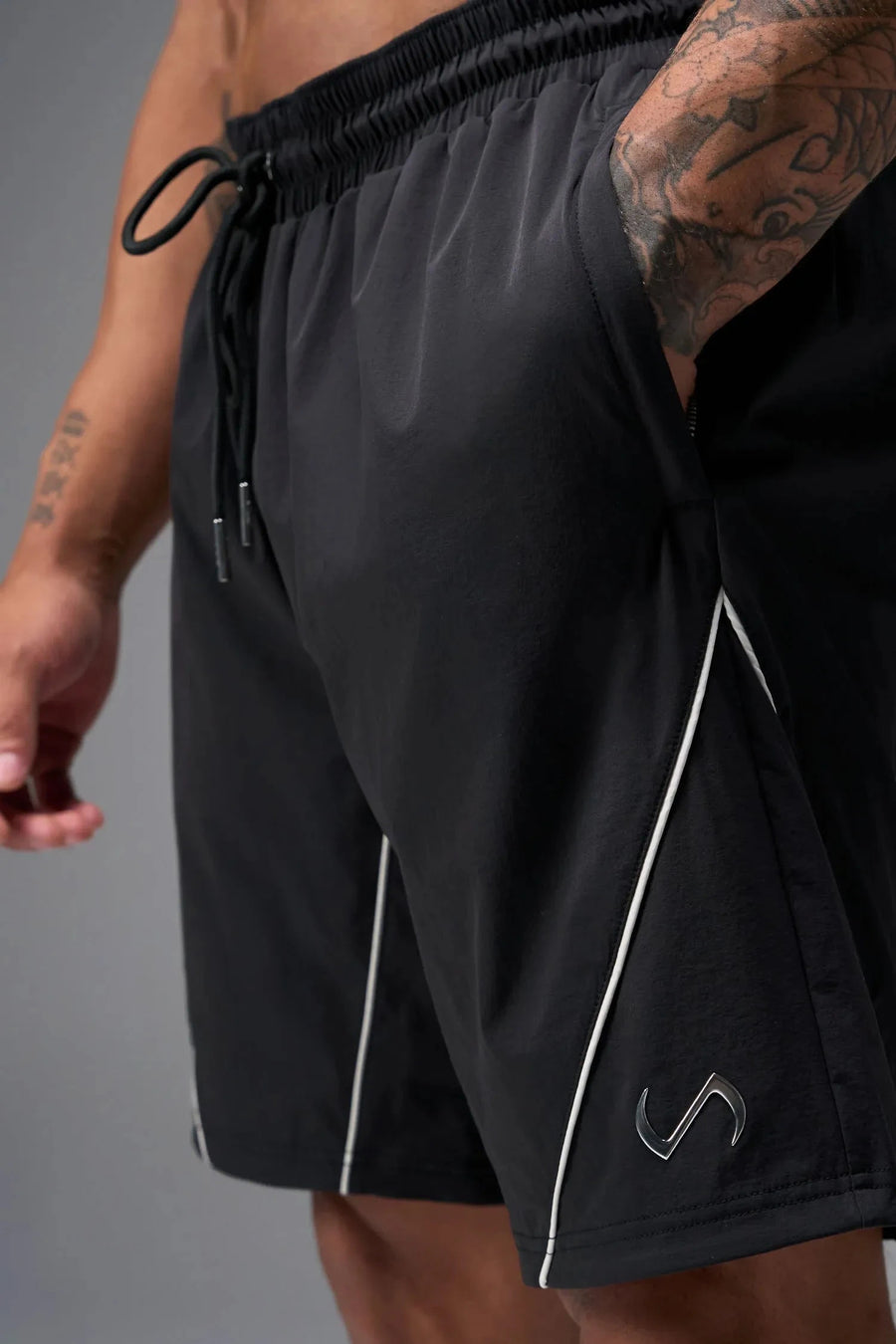 Front View of Black TLF Track Shorts (Men’s GTS Gym-To-Street Edition) featuring side zipper pockets, mesh lining and reflective piping details.