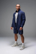 Front View of Blue TLF Track Shorts (Men’s GTS Gym-To-Street Edition) featuring side zipper pockets, mesh lining and reflective piping details.