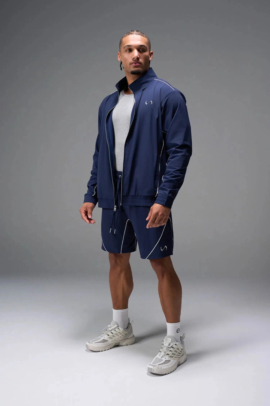 Front View of Blue TLF Track Shorts (Men’s GTS Gym-To-Street Edition) featuring side zipper pockets, mesh lining and reflective piping details.