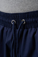 Detail View of Blue TLF Track Shorts (Men’s GTS Gym-To-Street Edition) featuring side zipper pockets, mesh lining and reflective piping details.