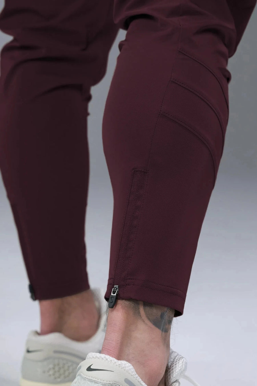 Side View of Maroon TLF Train Element 7/8 Joggers 2.0, featuring side cargo pockets in an athletic 7/8 length and side zipper pockets 