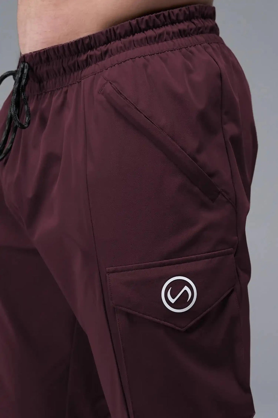Detail Front View of Maroon TLF Train Element 7/8 Joggers 2.0, featuring side cargo pockets in an athletic 7/8 length and side zipper pockets 