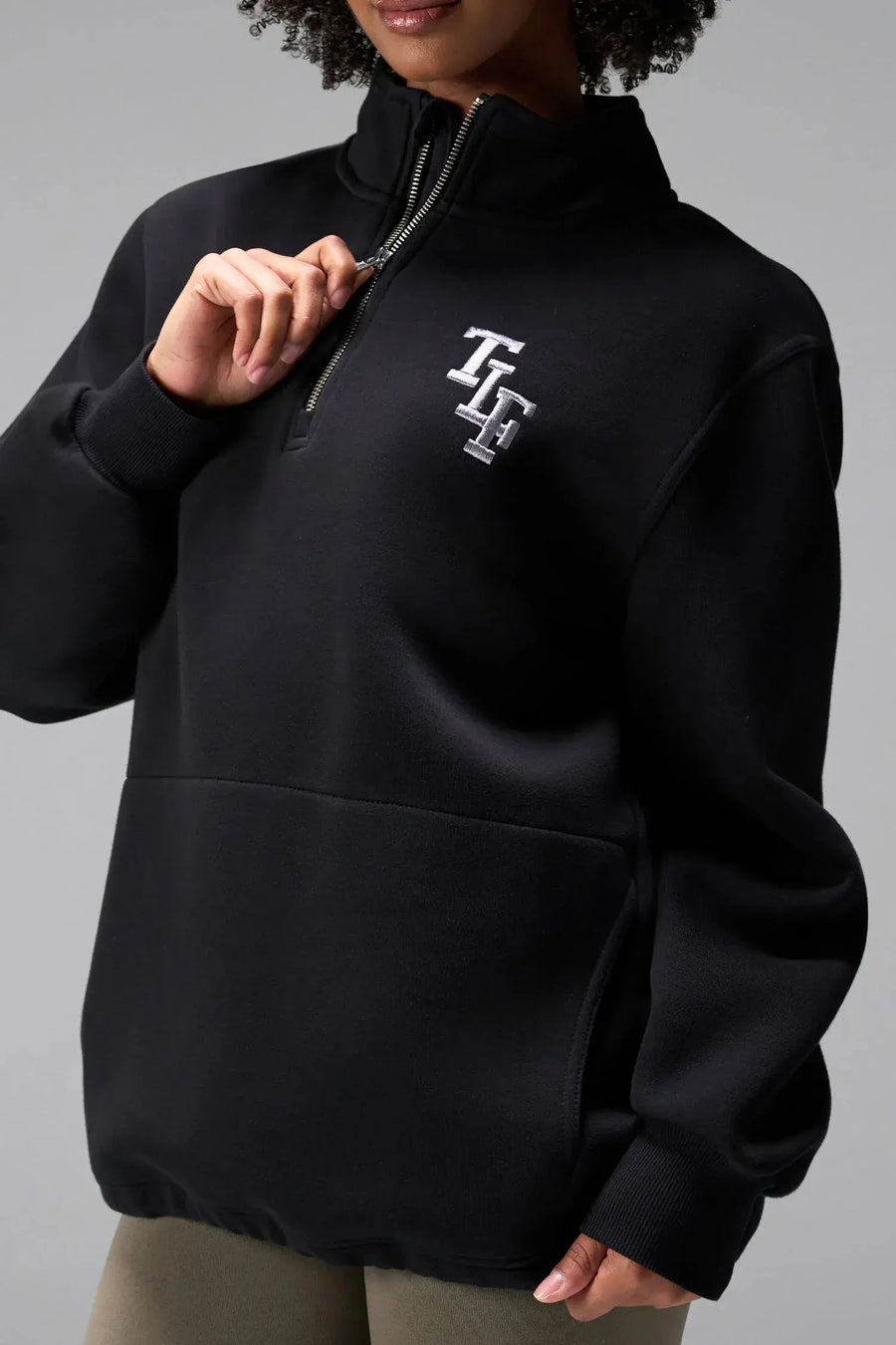  

Front View of Black TLF GTS Scuba Tech Quarter-Zip Pullover, featuring a ¼ zip pullover, sleek design and kangaroo pockets 