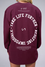 Back View of Red the TLF Redefine Original Cotton Luxe Oversized LS Tee that features a bold back graphic in an oversized fit. 