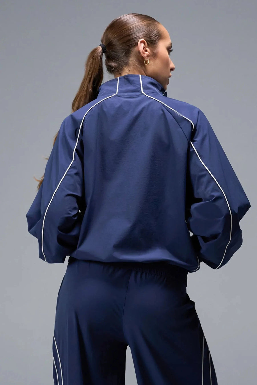 Back View of Blue TLF Track Jacket (Women’s GTS Gym-To-Street Edition) with mesh lining, reflective piping, and premium trims.