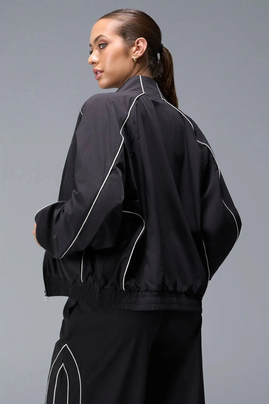 Back View of Black TLF Track Jacket (Women’s GTS Gym-To-Street Edition) with mesh lining, reflective piping, and premium trims.