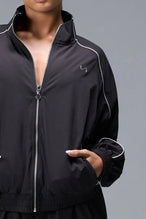 Detail Front View of Black TLF Track Jacket (Women’s GTS Gym-To-Street Edition) with mesh lining, reflective piping, and premium trims.