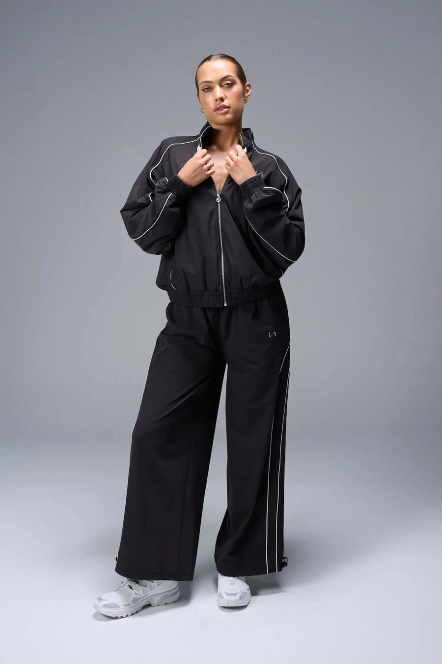 Front View of Black TLF Track Jacket (Women’s GTS Gym-To-Street Edition) with mesh lining, reflective piping, and premium trims.