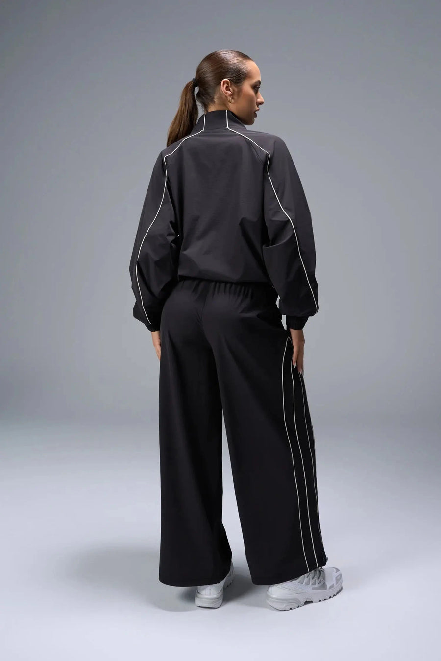 Back View of Black TLF Track Jacket (Women’s GTS Gym-To-Street Edition) with mesh lining, reflective piping, and premium trims.