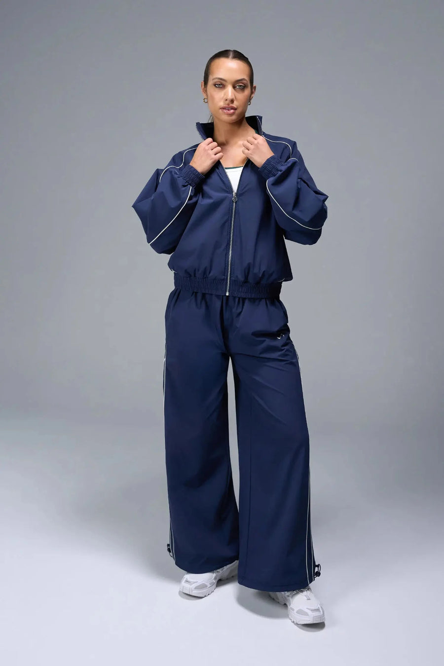 Front View of Blue TLF Track Jacket (Women’s GTS Gym-To-Street Edition) with mesh lining, reflective piping, and premium trims.