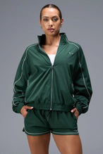 Front View of Green TLF Track Jacket (Women’s GTS Gym-To-Street Edition) with mesh lining, reflective piping, and premium trims.