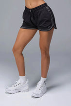 Front View of Black TLF Track Shorts (Women’s GTS Gym-To-Street Edition) featuring side pockets, mesh lining and reflective piping details.