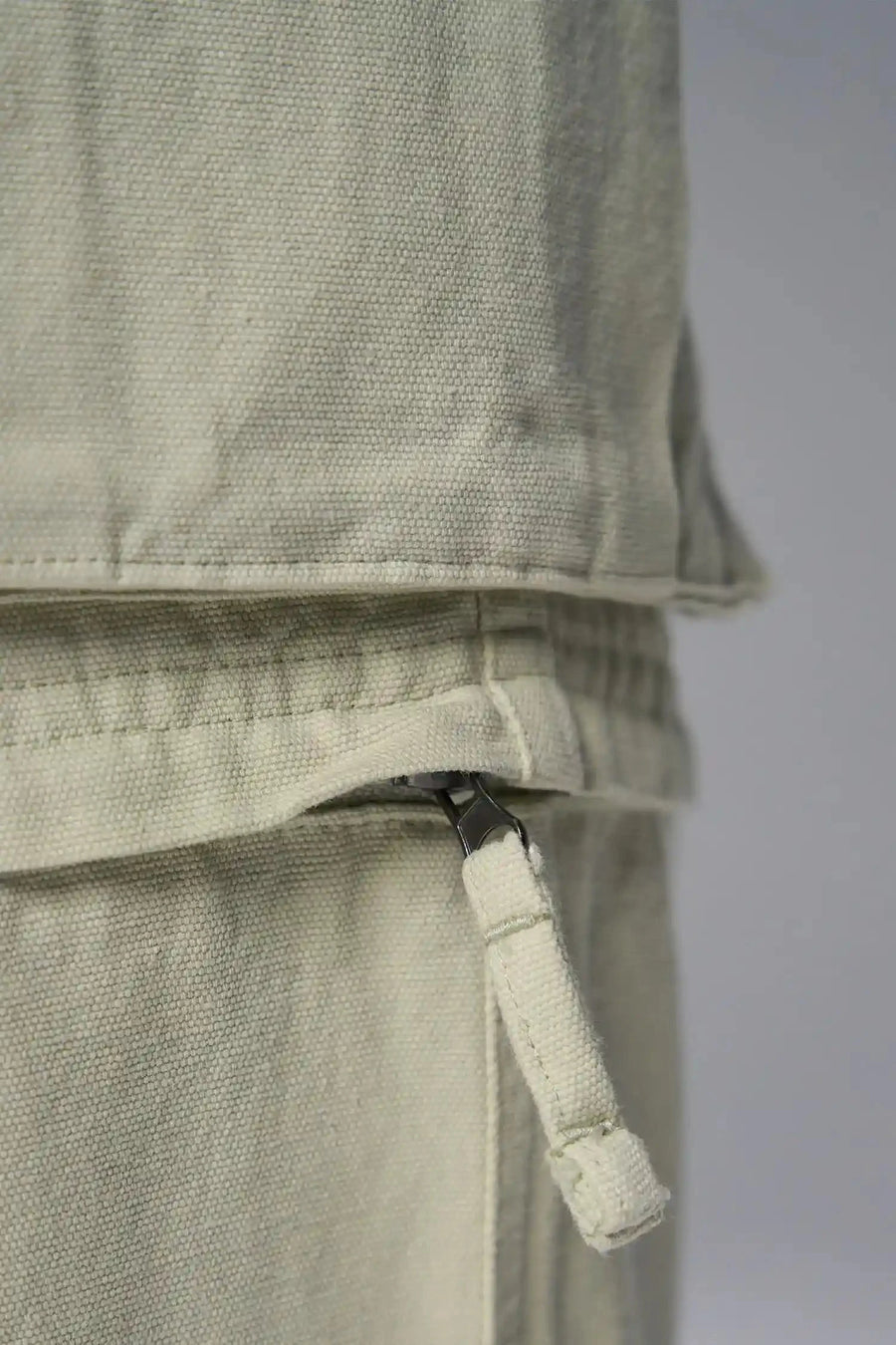 Detail View of Green the TLF Zip off cargo pants featuring side cargo pockets and a zip off design that transforms them into shorts