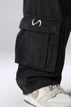 Detail View of Black the TLF Zip off cargo pants featuring side cargo pockets and a zip off design that transforms them into shorts