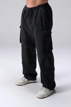 Front View of Black the TLF Zip off cargo pants featuring side cargo pockets and a zip off design that transforms them into shorts
