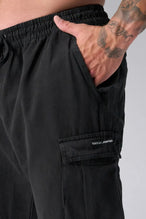 Front View of Black the TLF Zip off cargo pants featuring side cargo pockets and a zip off design that transforms them into shorts